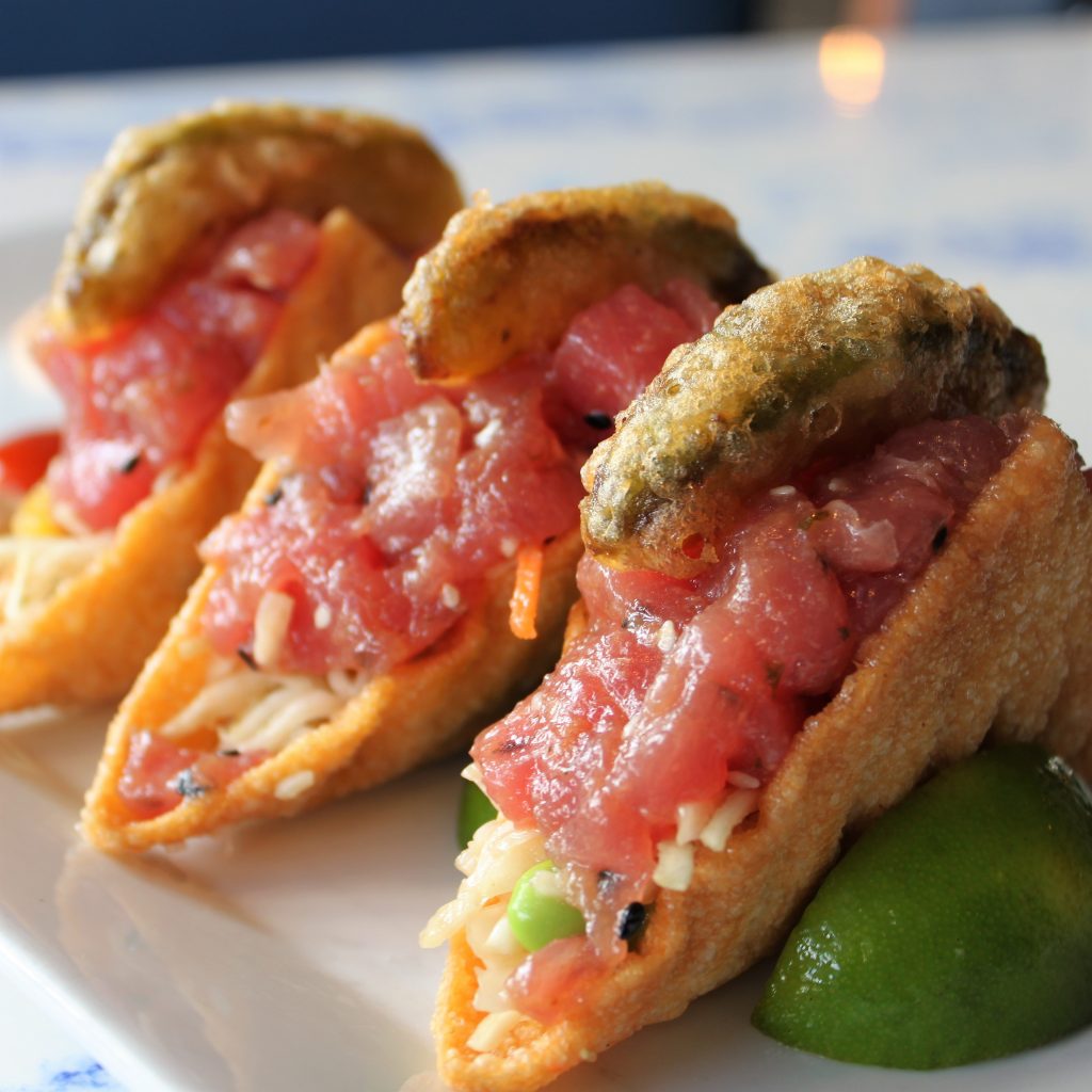 Three ahi tuna tacos in crispy fried wonton shells with lime
