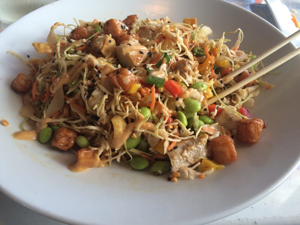 Asian chopped salad with chicken, edamame, peppers, cabbage, sesame, and chopsticks