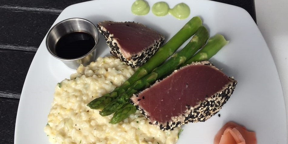 Sesame-crusted seared ahi tuna with creamy risotto, asparagus, wasabi, and soy