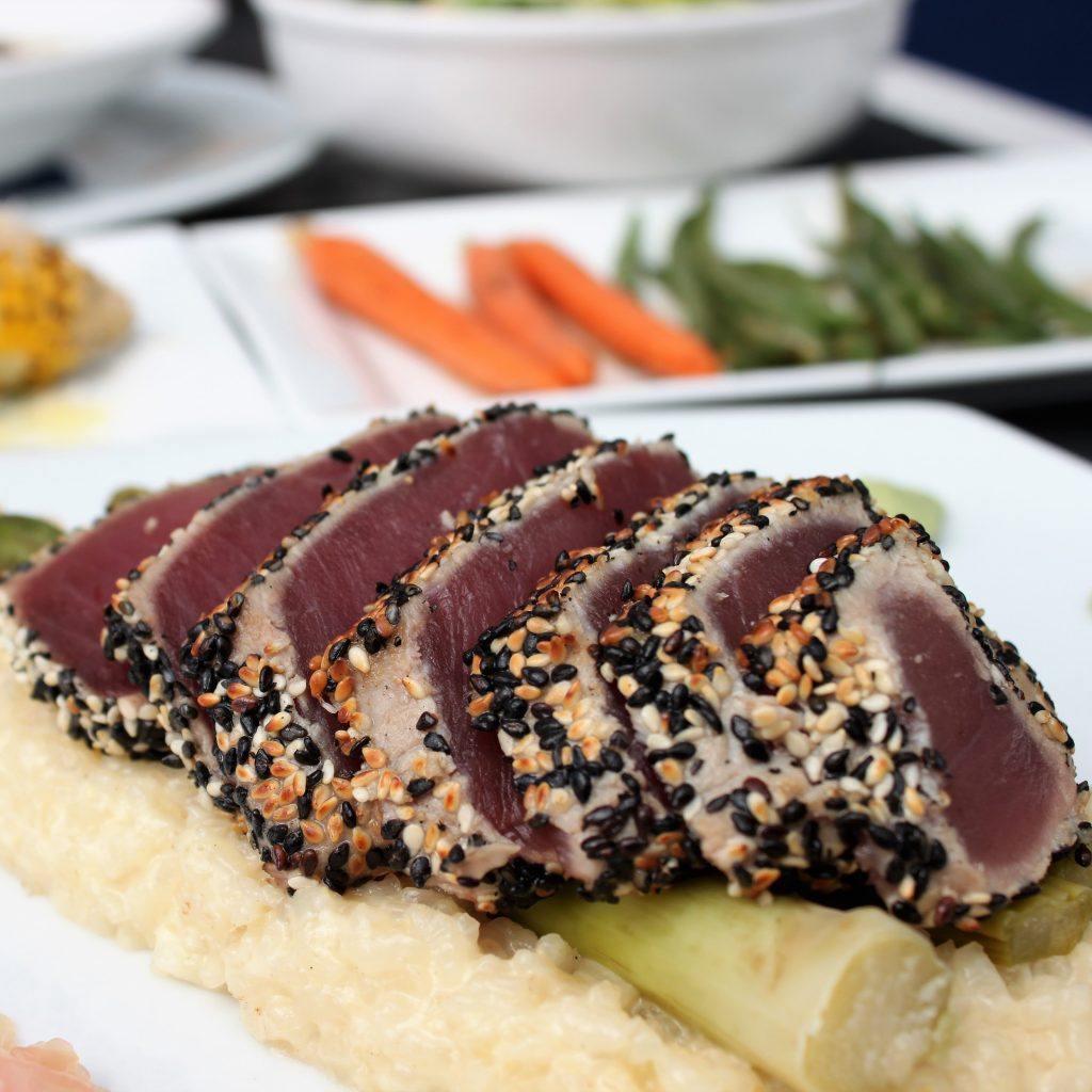 Sesame-crusted seared ahi tuna sliced over creamy risotto