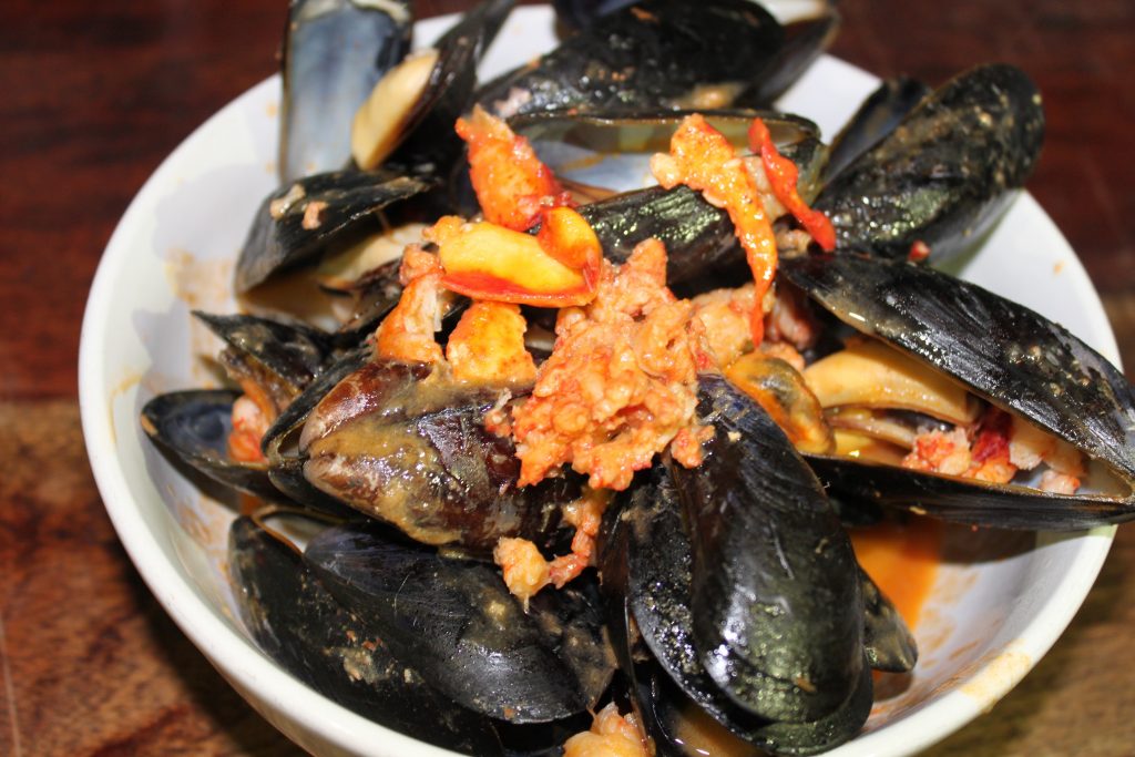 Bowl of Prince Edward Island mussels in spicy red tomato sauce