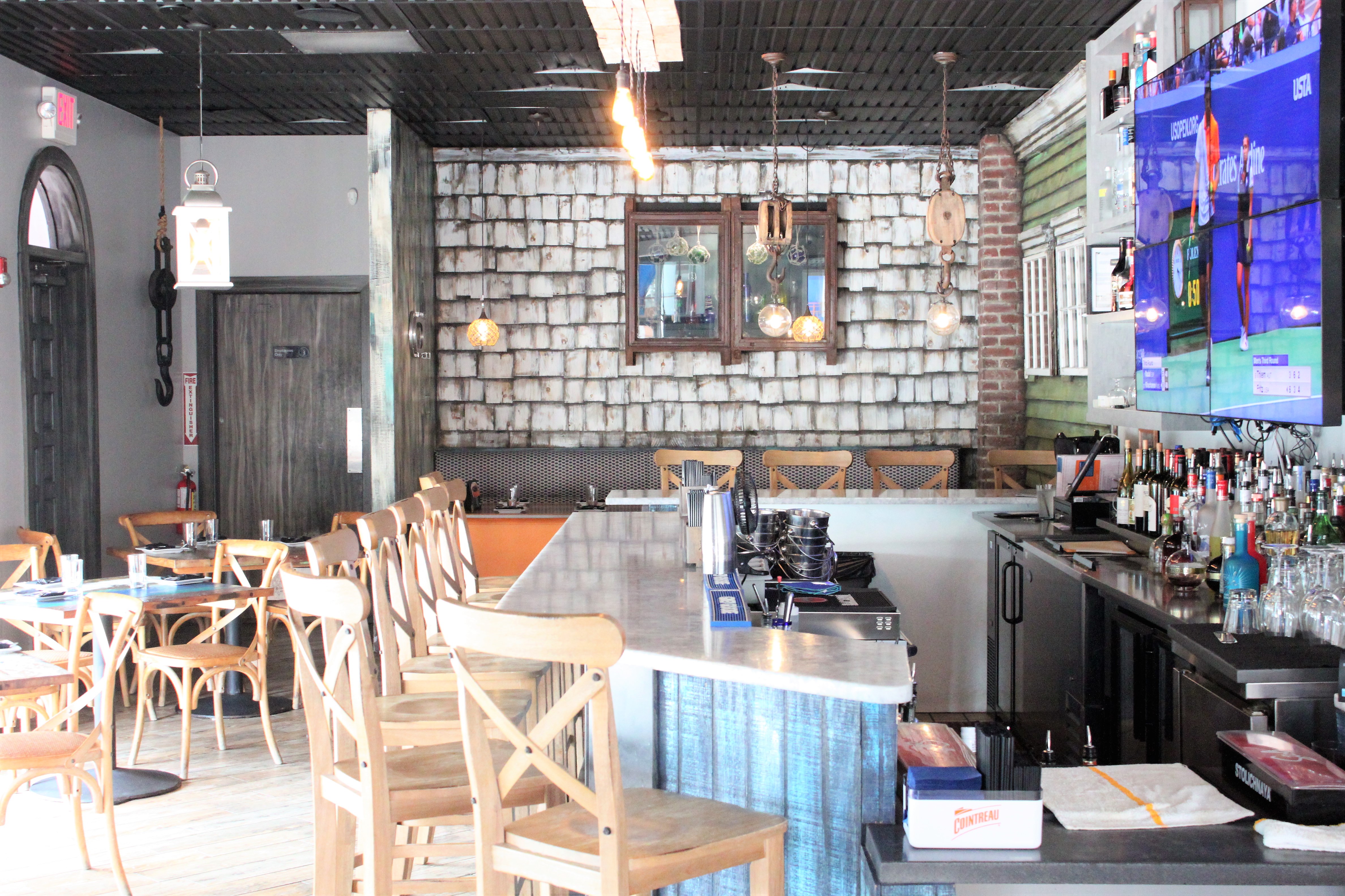 Bar area with stone wall, pendant lights, and wooden bar stools