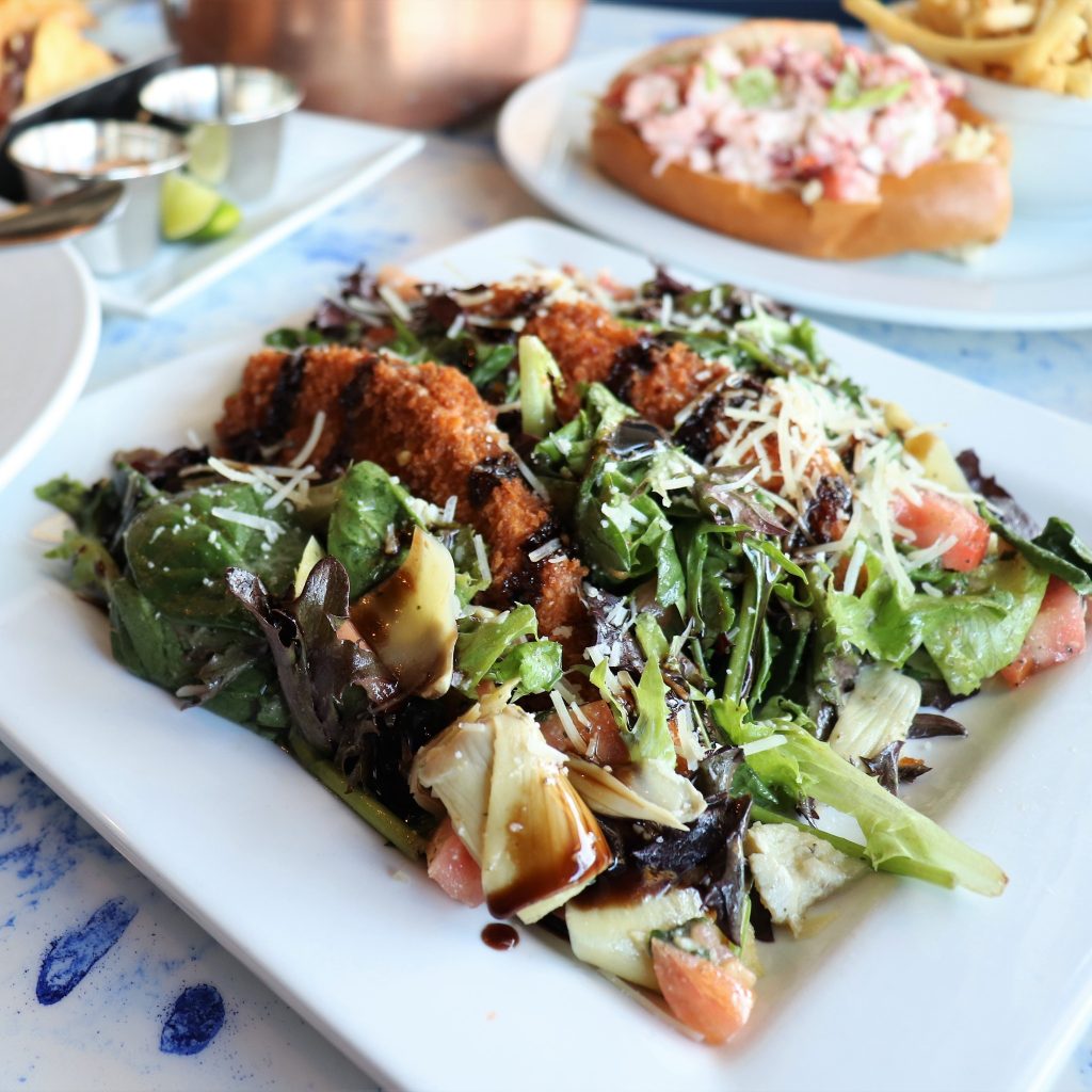Chicken Milanese - Arugula, tomato, artichoke, parmesan, lemon herb vinaigrette, balsamic reduction.